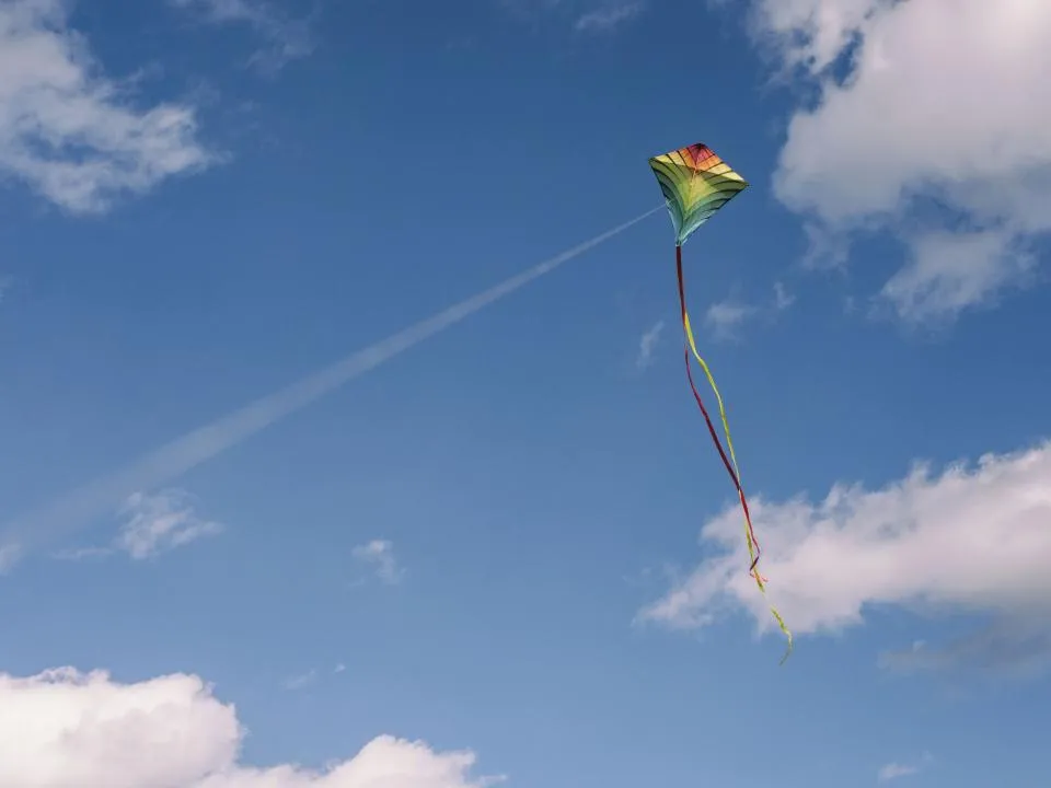 A colorful kite flying in a bright blue sky