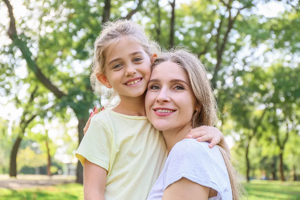 A smiling parent and child outdoors