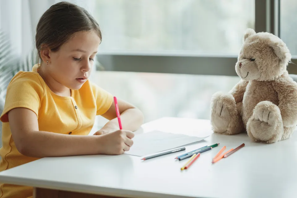 A child drawing at a table